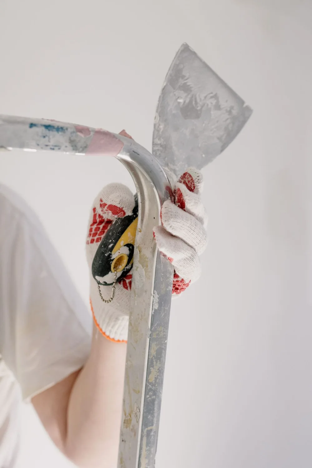 Handyman preparing a wall with a putty knife