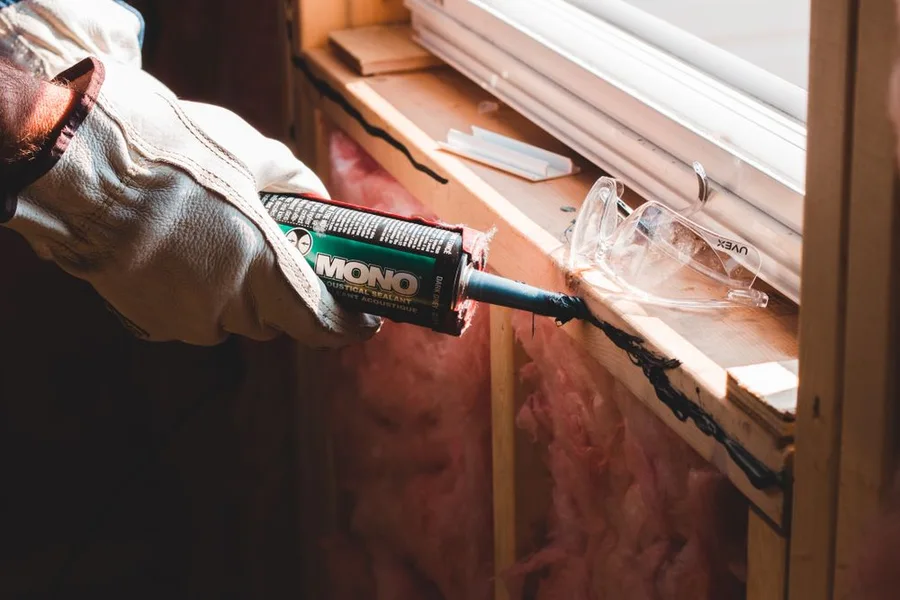 Applying silicone sealant around a window frame